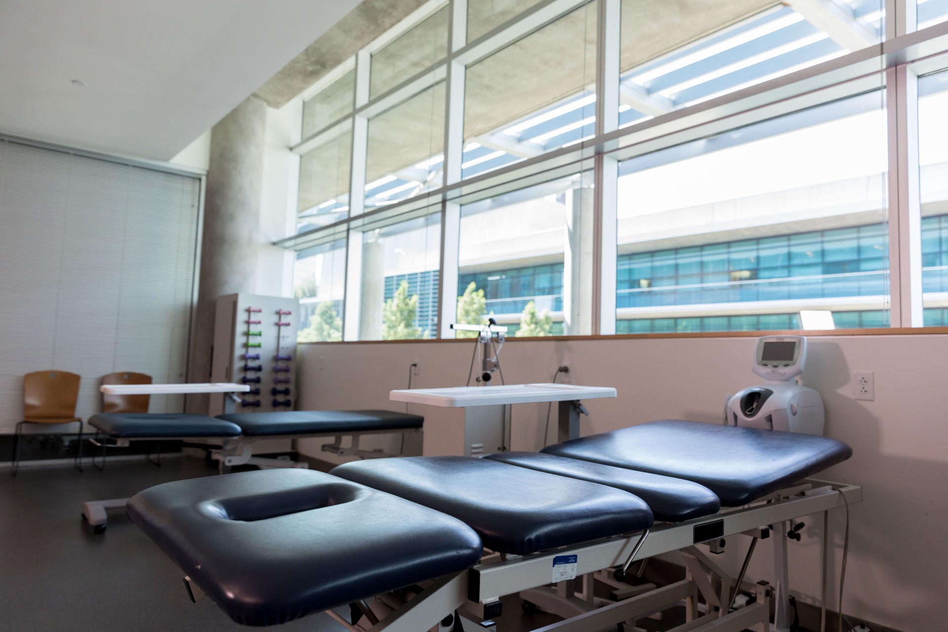 Modern, clean, physical therapy room with equipment and natural light